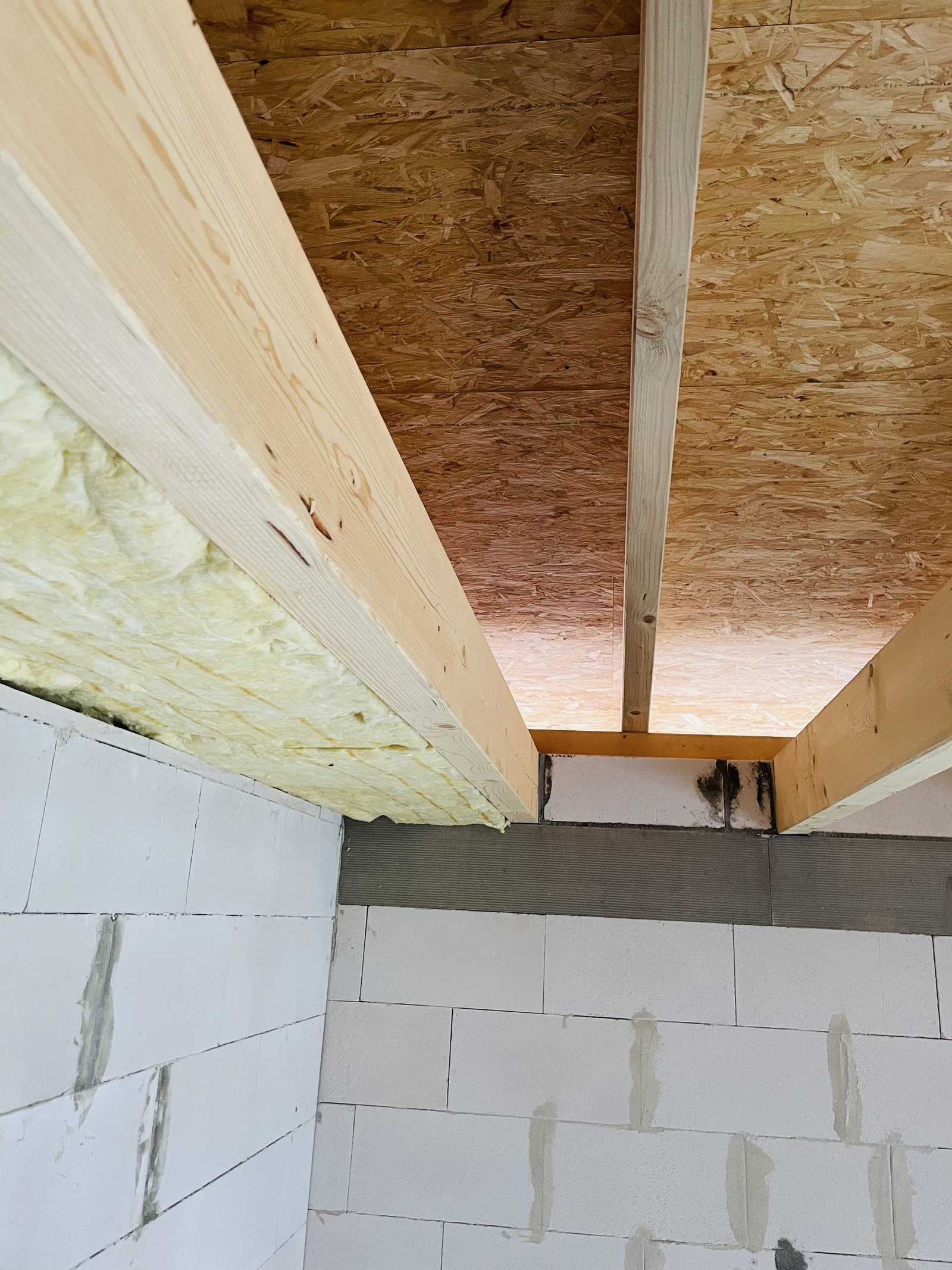 Dämmung zwischen den Holzbalken einer Deckenkonstruktion.