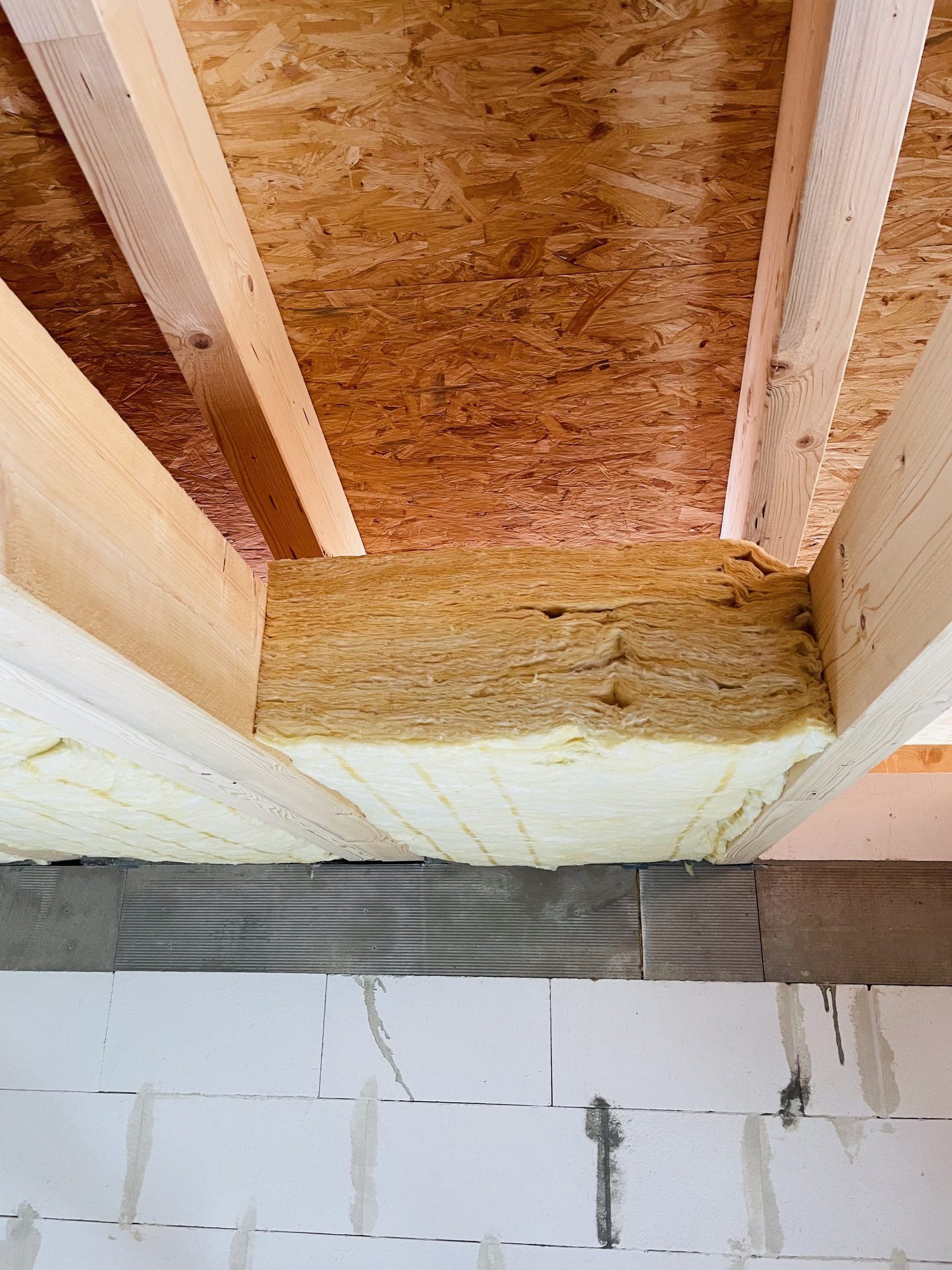 Nahaufnahme der eingebauten Dämmung zwischen den Holzbalken.